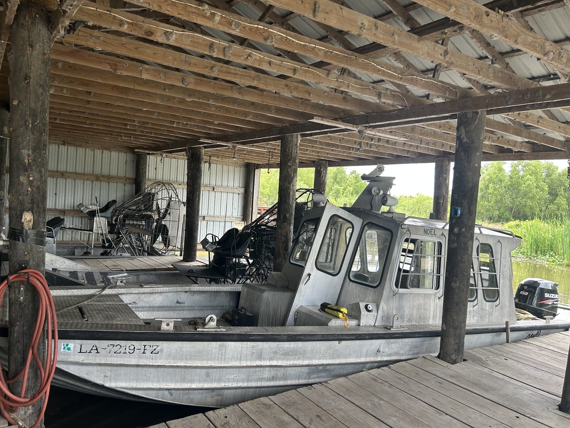 Airboat and crew boat staged under the boathouse at the Melancon Marine yard