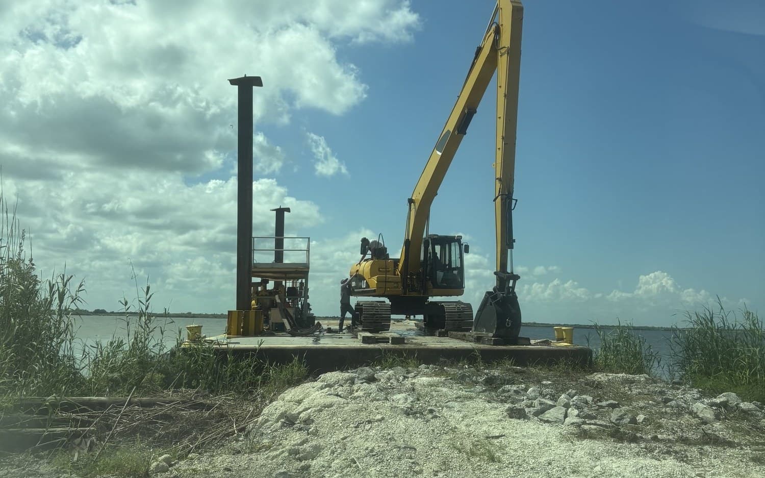 Long-reach excavator and pile-driving rig working from a barge in South Louisiana