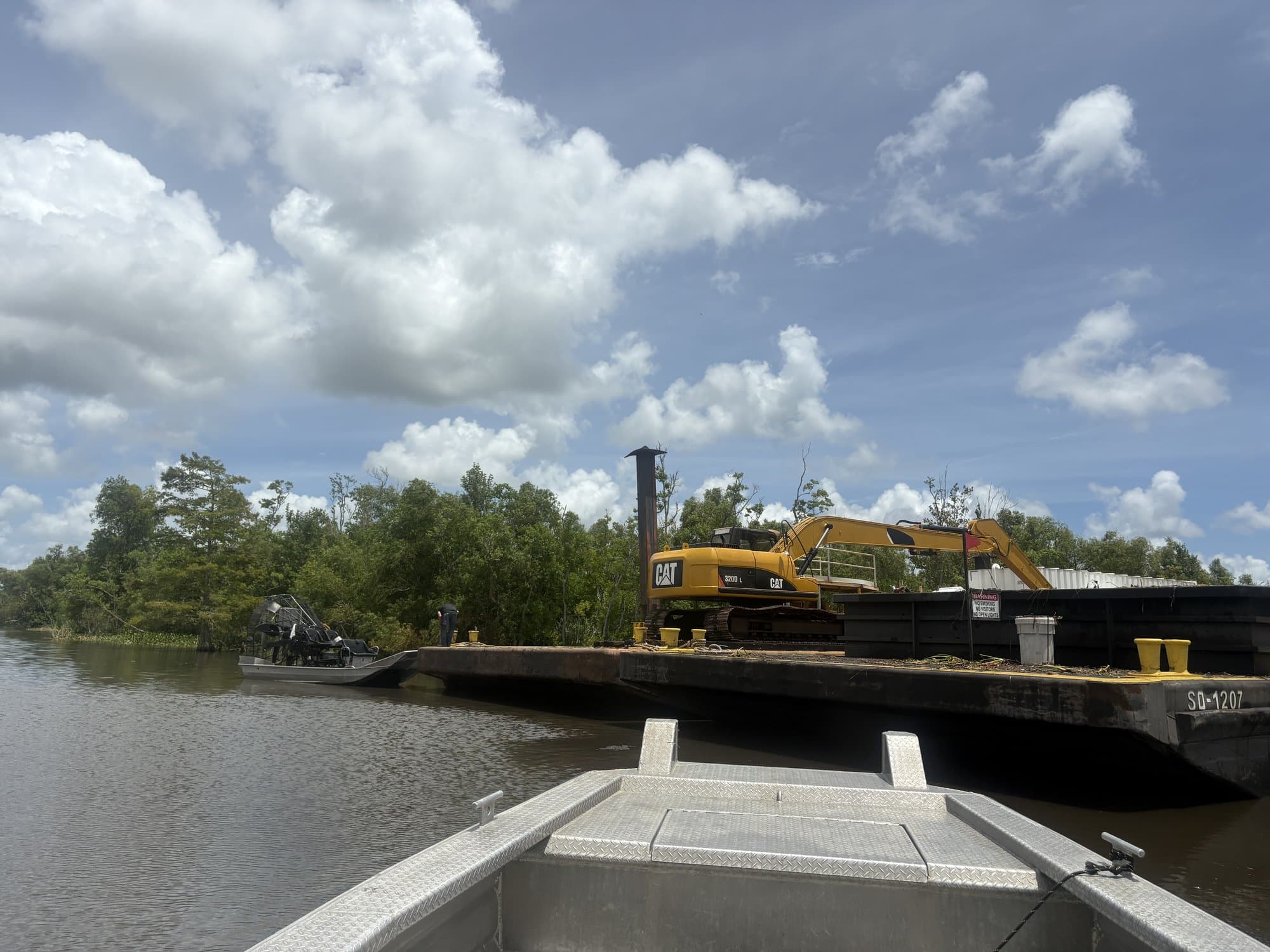 Excavator working from a barge on a Louisiana bayou